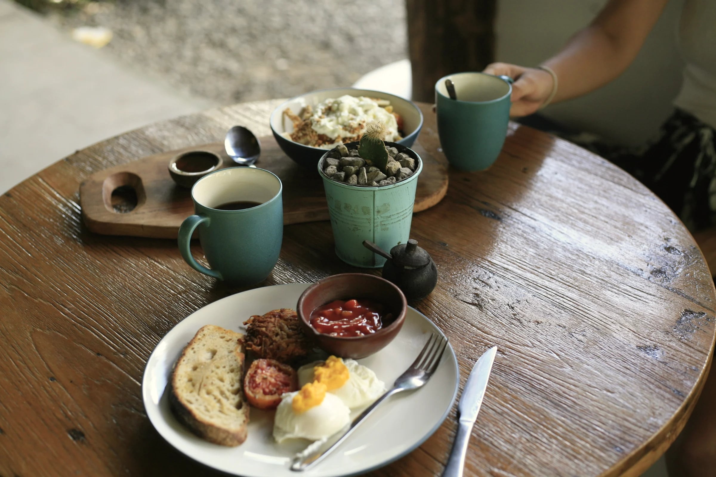 Breakfast of eggs, toast and coffee on a round wooden table